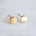 Pendientes redondos de oro mate con textura de metal cepillado sobre fondo de mármol blanco - Dorado