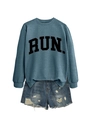 Detail of vintage blue crewneck sweatshirt featuring black RUN letters and ripped denim shorts - Blue (Black Font)
