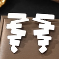 Macro shot of mirror-polished silver geometric stainless steel stud earrings on display - Silver (C1324)