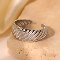 Macro detail of silver croissant ring with diagonal spiral texture on stone surface - Silver Style (C3348)