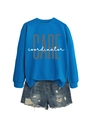Detail of bright blue crewneck sweatshirt and distressed denim shorts with frayed hems - Lake Blue (White Print)