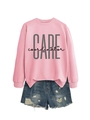 Detail of pink CARE coordinator sweatshirt paired with distressed blue denim shorts - Pink (Black Print)