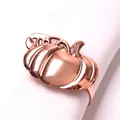 Macro shot of rose gold pumpkin napkin ring with detailed metal texture on white fabric - Rose Gold Textured Pumpkin Style