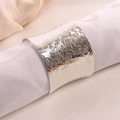 Detail of silver rose embossed napkin ring on white cloth with elegant table setting - Silver
