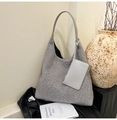 Detail of grey shearling hobo tote bag with matching coin purse on leather background - Gray