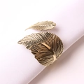 Servilletero vintage de metal dorado con forma de hoja sobre tela blanca - Estilo Hoja de Oro Antiguo