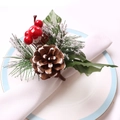 Detalle de un servilletero navideño con piña de pino y bayas rojas festivas - Piña de pino