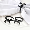 Halloween black spider napkin rings with rhinestones on a white plate and napkin - Black