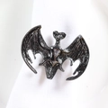 Détail du rond de serviette chauve-souris noir avec textures d'ailes sur tissu blanc - Chauve-souris
