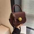 Dark brown suede saddle bag with large gold circular buckle and adjustable shoulder strap - Brown