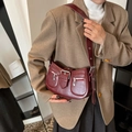 Vintage-Schultertasche in Burgund mit Silberschnallen an einem Model getragen - Rot
