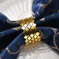 Portatovaglioli ondulato in metallo dorato con design geometrico su tovagliolo blu - Oro