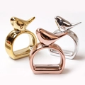 Polished bird-shaped napkin rings in gold, rose gold, and silver metallic finishes - Bird