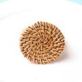 Macro shot of handcrafted round woven rattan napkin ring with intricate spiral texture - Spiral Woven Style