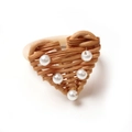 Close-up of heart-shaped woven rattan napkin ring with white pearl bead accents - Woven Heart Style