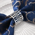 Silver hollow patterned metal napkin ring set on an elegant blue embroidered napkin - Tarnish Resistant Thick Silver