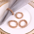 Gros plan de quatre ronds de serviette en cristal champagne sur une assiette blanche - Champagne