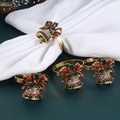 Detailed close-up of 4 gold Christmas bell napkin rings with red and green rhinestones - Christmas Bell Napkin Ring