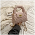 Close-up of pink quilted faux leather bag with gold clasp and semi-circular handle - Pink
