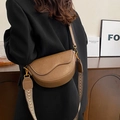 Brown vintage saddle bag with textured leather and woven strap on a female model - Khaki