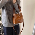 Karamellbraune Eimer-Tasche aus Ölwachsleder mit klobigem Kettengriff und Logo-Detail - Braun