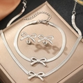 Detail shot of bow-knot necklace and earrings set displayed on a luxury gold jewelry box - Silver (C6050)