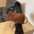 Brown suede cylindrical Boston bag with leather strap on a decorative stone base - Coffee