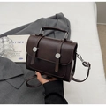 Detail of dark brown leather crossbody bag featuring metal buckle and vintage handle - No Pendant / Brown