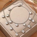 Dettaglio macro di gioielli in acciaio inossidabile con ciondoli a cuore su seta - Stile Cuore d'Argento (C6052)
