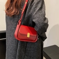Bolso bandolera de cuero rojo con cierre giratorio dorado sobre abrigo de lana - Rojo