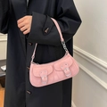 Pink faux suede crossbody bag with utility pockets shown on a model in a black coat - Pink