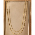 Elegante cadena de cuerpo dorada con pequeñas cuentas sobre un estuche de cuero oscuro - Dorado (F333)