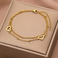 Close-up of golden double-layer stainless steel heart bracelet on elegant silk packaging - Gold Style (B4615)