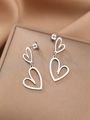 Dettaglio di orecchini a doppio cuore d'argento su sfondo di raso champagne - Argento (N8450)