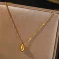 Dettaglio del ciondolo a goccia dorato su una sottile catena in acciaio al titanio - Stile Goccia d'Acqua Dorata (C1965)