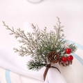 Detail of Christmas napkin ring with snowy cedar, pine cones and red berries on white plate - True Pine Cone Cedar