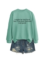 Flat lay of mint green sweatshirt with text print and distressed denim shorts - Light Green (Black Font)