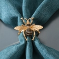 Servilletero de abeja dorada con esmalte negro sobre servilleta de lino verde mar - Abeja Dorada