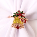 Vue détaillée d'un rond de serviette cloche de Noël dorée avec strass sur tissu blanc - Cloche en Strass