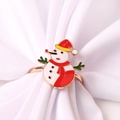 Close-up of golden Christmas napkin ring featuring a cute enamel snowman on fabric - Snowman