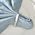 Modern silver rectangle metal napkin ring with polished finish on blue linen napkin - Silver