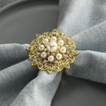 Golden floral napkin ring with pearls and rhinestones on a blue cloth napkin - Gold