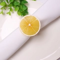 Dettaglio di un portatovagliolo a forma di limone realistico su un tovagliolo bianco - Stile Arancia