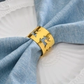 Rond de serviette renne doré ajouré sur serviette bleue et assiette blanche - Doré