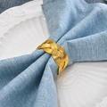 Golden woven metal napkin ring with spiral texture on a soft blue linen fabric - Gold