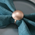 Modern rose gold metal napkin ring with matte dome finish on a blue linen napkin - Rose Gold
