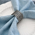 Modern wave pattern hollow metal napkin ring in silver finish on blue linen napkin - 1 Piece / Black