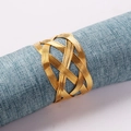 Artistic gold hand-woven metal napkin ring on a textured light blue cloth napkin - Gold