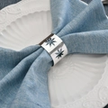 Elegant silver metal napkin ring with hollow snowflake pattern on blue napkin - Silver