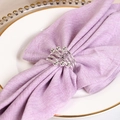 Silver spiral metal napkin ring with polished sphere ends on a purple linen napkin - Silver